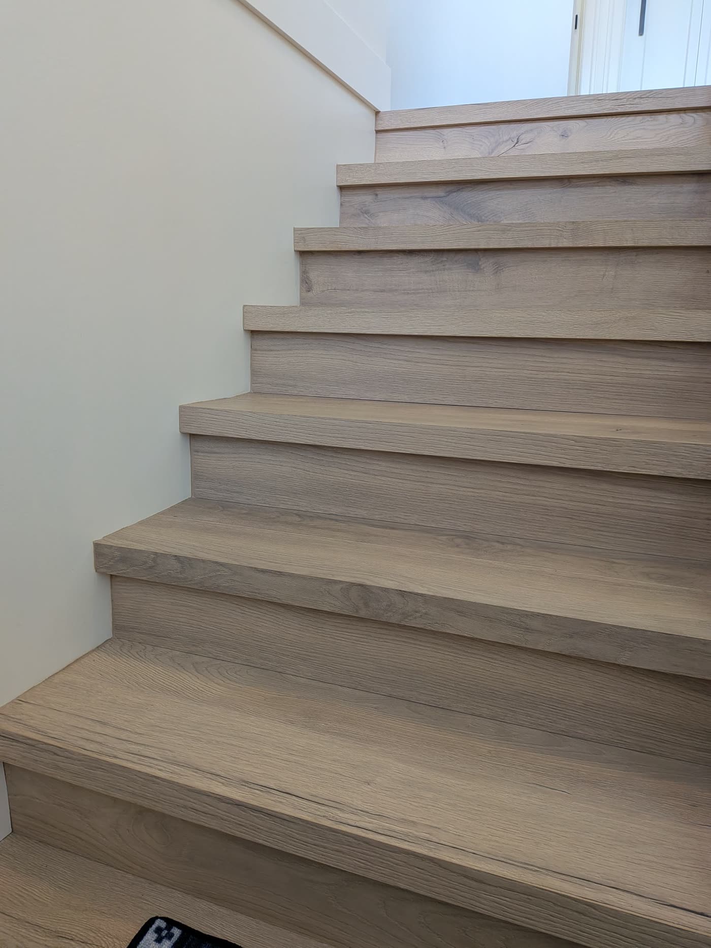 Close view of new wood-look stair treads in Burnaby home renovation