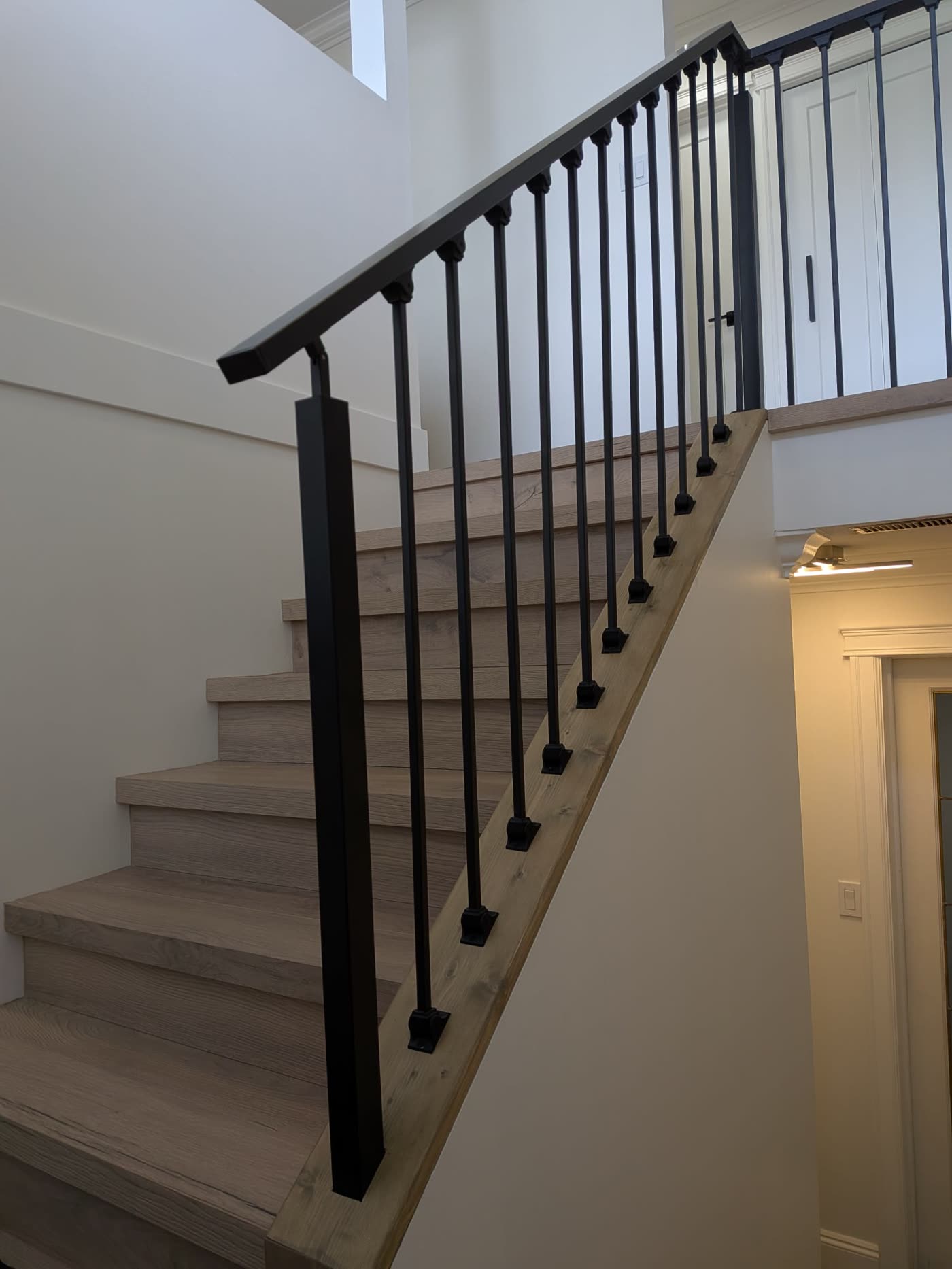 Renovated Burnaby staircase with new treads and black railing