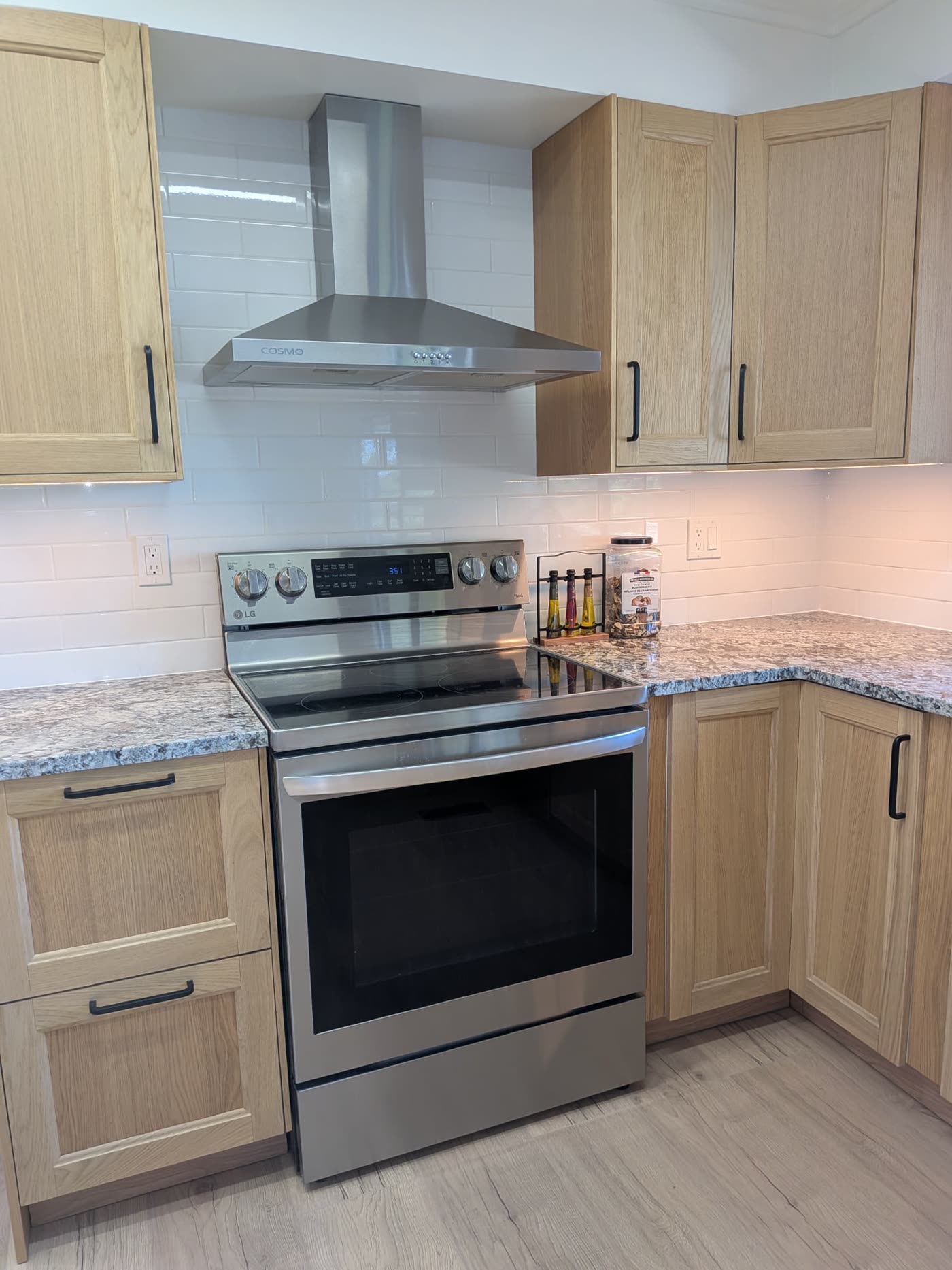 New kitchen cabinetry range hood and subway tile backsplash in Burnaby