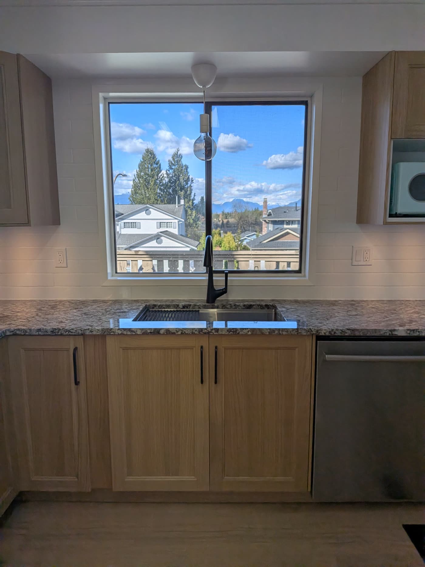 Renovated Burnaby kitchen sink area with mountain view