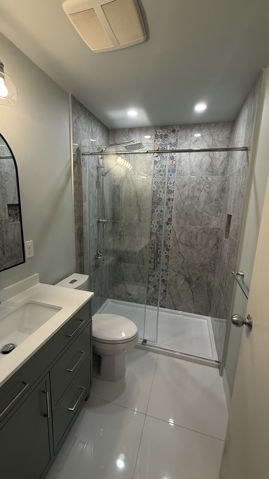 Completed Budova walk-in shower renovation with glass doors, vanity and accent tile